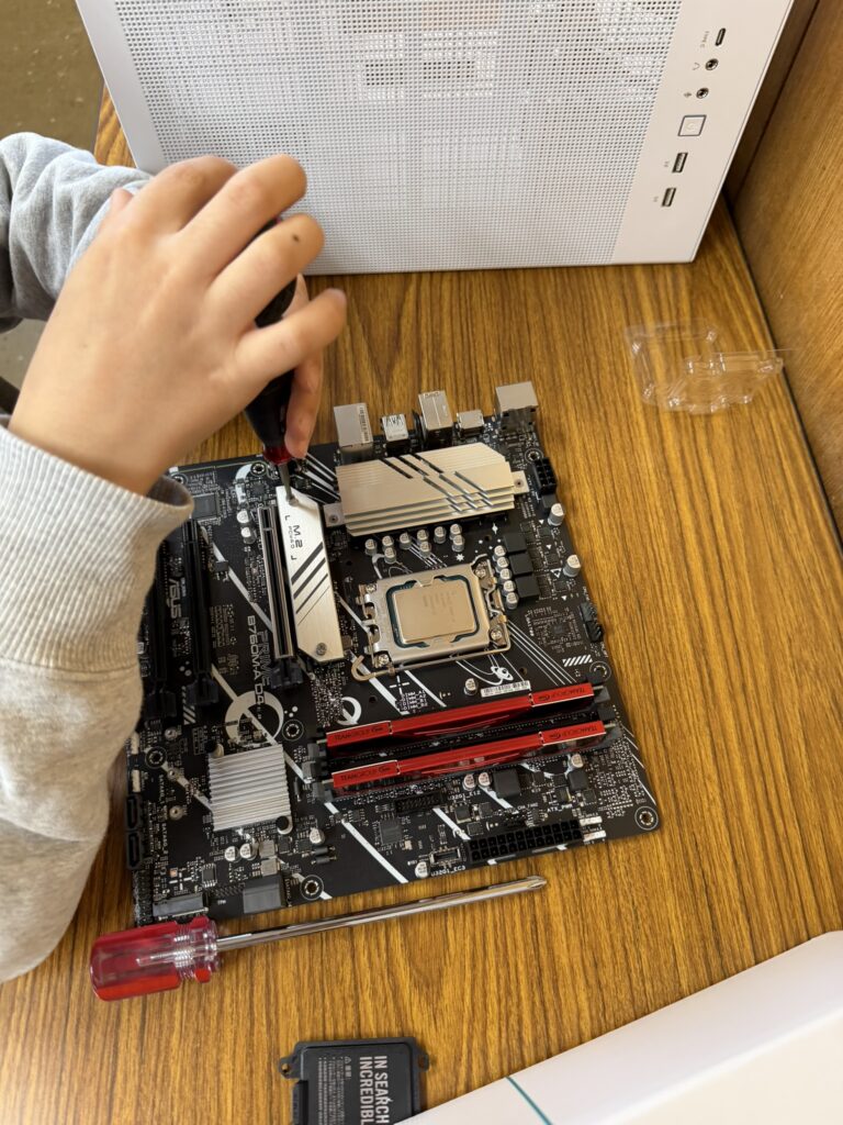 "子どもがドライバーを使ってPCケースにパーツを取り付けている様子"