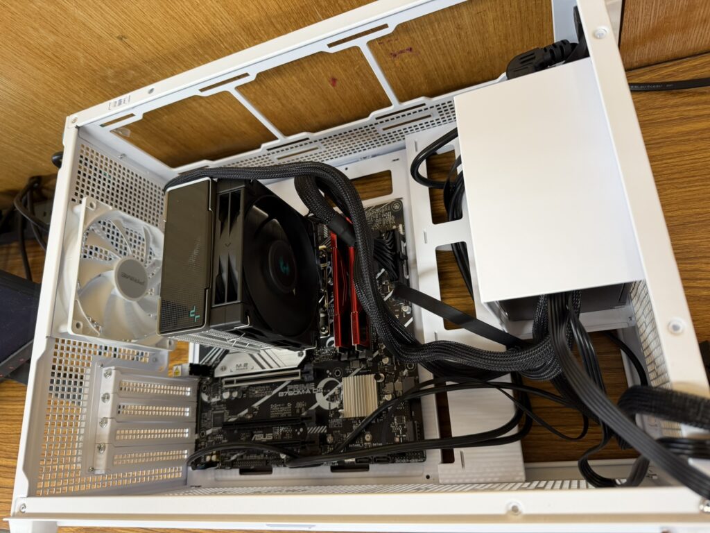 ="完成したPC内部。ASUS Prime AP201ケースにマザーボード、CPUクーラー、電源、ケースファンが収まっている"